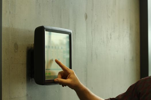 hand and arm controlling a room with a computer pad. with finger pointing