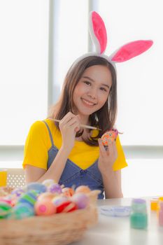 Portrait of a happy young woman wearing Easter bunny ears prepares to celebrate Easter