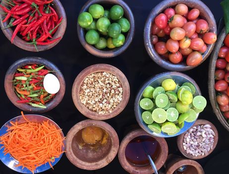 Rustic style raw vegetables, spices in clay or ceramic pots. Top view organic vegetables tomato, hot pepper, carrot, lime in a bowls.
