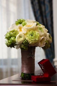 Bouquet of white roses and silver wedding rings