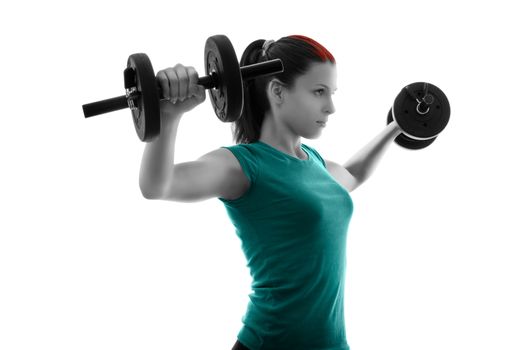 Fit attractive young woman working out with a set of dumbbells, backlit silhouette studio shot isolated on white background. Fitness and healthy lifestyle concept.