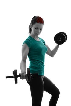 Fit attractive young woman working out with a set of dumbbells, looking down, backlit silhouette studio shot isolated on white background. Fitness and healthy lifestyle concept.