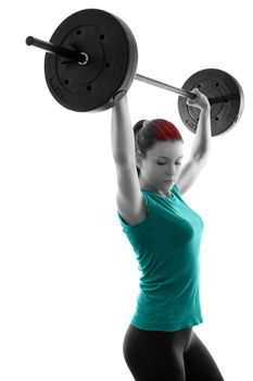 Fit attractive young woman working out with a barbell, doing shoulder press, backlit silhouette studio shot isolated on white background. Fitness and healthy lifestyle concept.