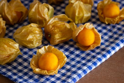 Cape gooseberry on blue tablecloth. Concept of health care or herb.