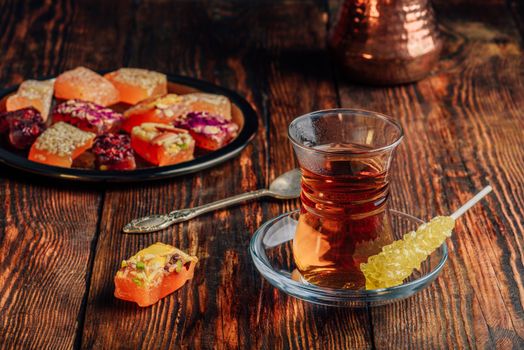 Tea in armudu glass with oriental delight rahat lokum over wooden surface