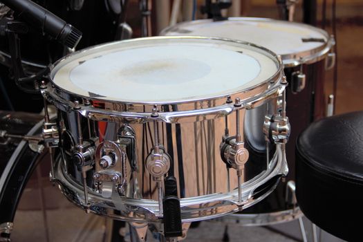 Silver snare drum ready to play with the rest of the kit.