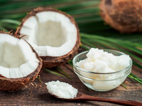 Liquid coconut MCT oil and halved coco-nut on wooden table. Health Benefits of MCT Oil. MCT or medium-chain triglycerides, form of saturated fatty acid.