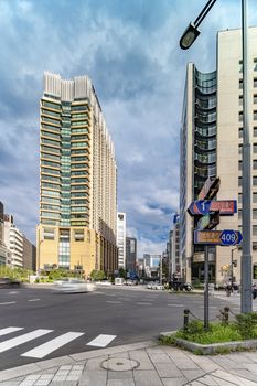 Crossing intersection of Hibiya Street and Harumi street at the entrance of the Hibiya Park (日比谷公園 Hibiya Kōen) in Chiyoda City of Tokyo in Japan. On the left is the The Peninsula Tokyo hotel and on the right is the Hibiya Marine building where Thai Airways is located. At the end of the Harumi street we can see the Ginza district. Harumi street is leading from the Iwaida Bridge intersection in Chiyoda Ward to the Shinonome intersection in Koto ward. 