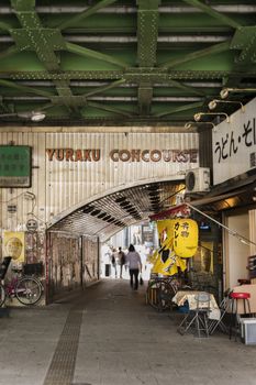 Underpass Yurakucho Concourse under the railway line of the station Yurakucho. Japanese noodle stalls and sake bars revive the nostalgic years of Showa air with old posters and placards glued to the walls of the tunnel.