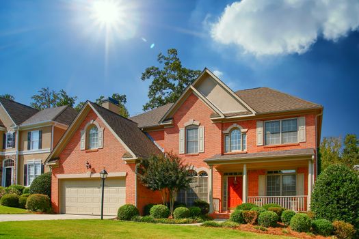 A nice brick home on a grassy lot with a red door