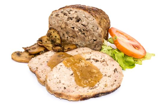 Meatloaf cut into slices with mushrooms, tomato and salad on an isolated white background.