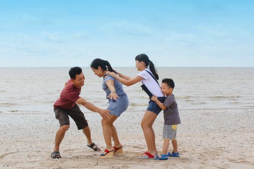 happy asian family having fun on beach.