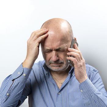 A middle-aged man worried while talking on a cell phone