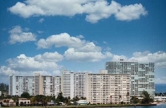 Huge white luxury condominium buildings on the coast by a shipping channel