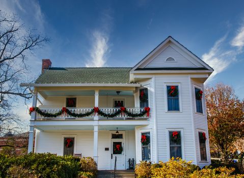 A traditional white two-story farm house decorated for Christmas