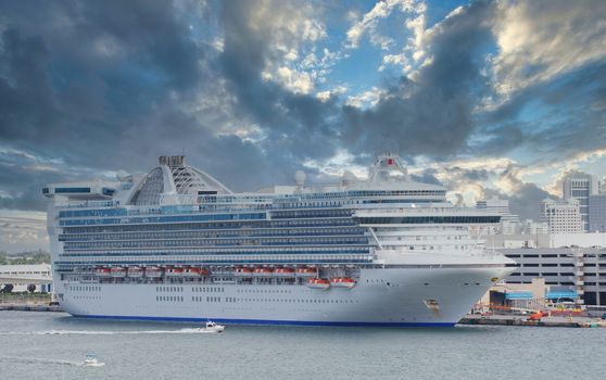 A huge white cruise ship at a calm blue bay