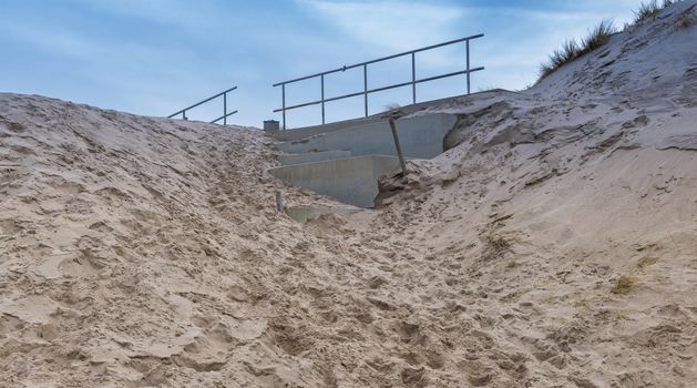 the stairs at the Maasvlakte beach are completely covered in sand by the February storms