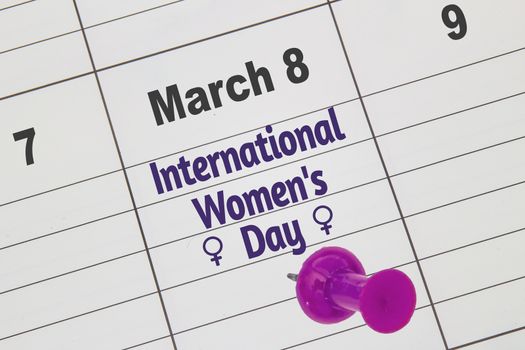 A close up to a Calendar on March 8 with the text: International Women's Day with a pink and woman's symbols.