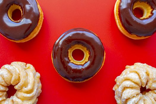 Chocolate Dip Donuts with Honey Cruller Donuts on a red background