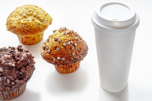 Single-use coffee Cup and muffin on white background