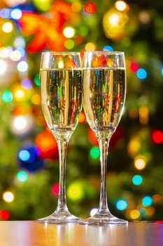 Sparkling wine with bubbles and some colorful light on the background