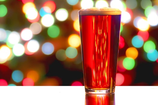 A close up of a Red Ale Beer with defocused lights in the background