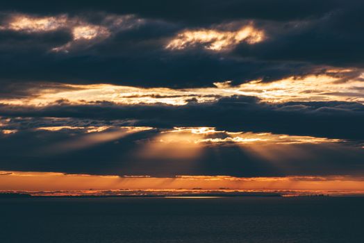 Sunrise on river. Sunbeams make a way through the clouds