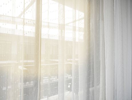 The bedroom in the city in the morning sunshine through the white curtains, giving a feeling of happiness, freshness, and warmth.