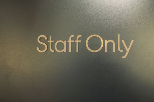 Closeup of staff only sign on a door outside . Staff Only Room.