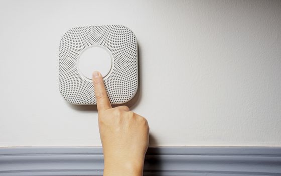 Smoke, fire and Carbon Monoxide Alarm being test with a soft shadow