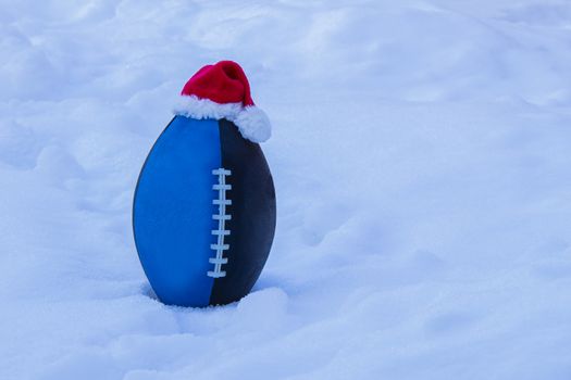 Blue Black Junior football wearing a Santa Claus Hat on Snow