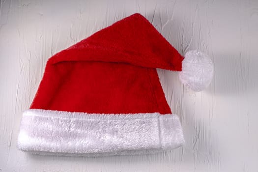 Folded Christmas Santa hat on a white texture background