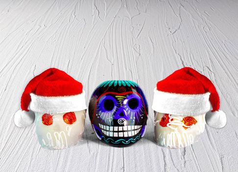 Traditional Mexican sugar skulls with Santa hats. Mexican Christmas.(calaveritas de azucar para navidad en México) mix cultures.
