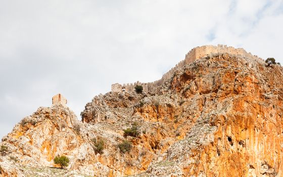 The fortified walls of Alanya Castle in Southern Turkey as viewed from the Mediterranean Sea.  The castle is located on a rocky peninsula and dates back to the 13th century.