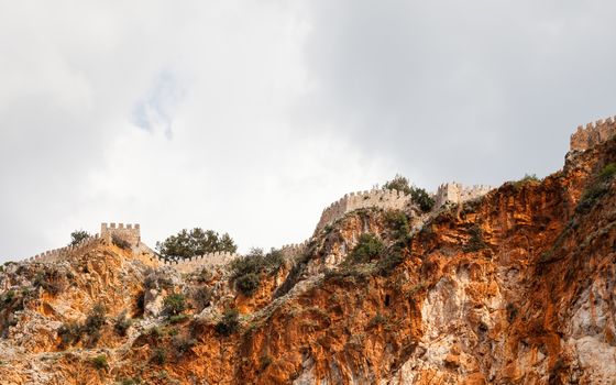 The fortified walls of Alanya Castle in Southern Turkey as viewed from the Mediterranean Sea.  The castle is located on a rocky peninsula and dates back to the 13th century.