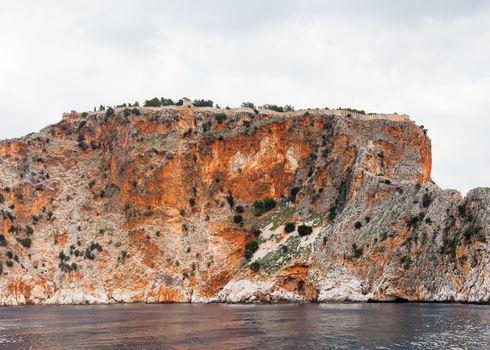 The fortified walls of Alanya Castle in Southern Turkey as viewed from the Mediterranean Sea.  The castle is located on a rocky peninsula and dates back to the 13th century.