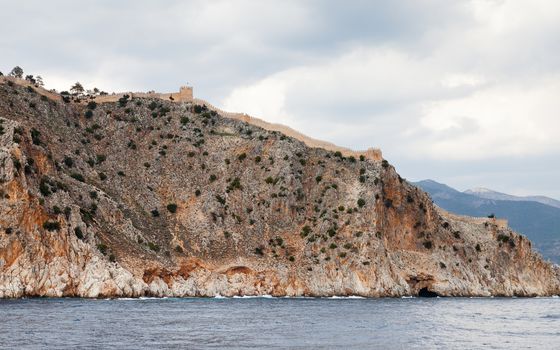 The fortified walls of Alanya Castle in Southern Turkey as viewed from the Mediterranean Sea.  The castle is located on a rocky peninsula and dates back to the 13th century.