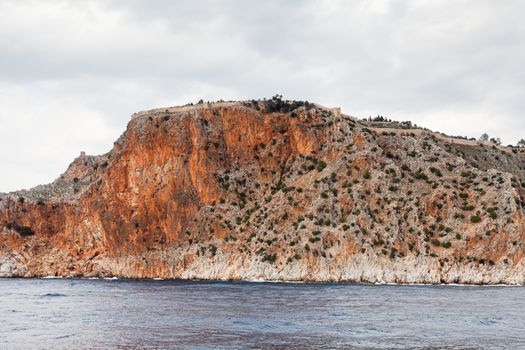 The fortified walls of Alanya Castle in Southern Turkey as viewed from the Mediterranean Sea.  The castle is located on a rocky peninsula and dates back to the 13th century.