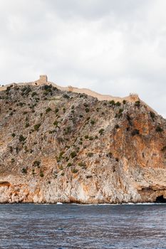 The fortified walls of Alanya Castle in Southern Turkey as viewed from the Mediterranean Sea.  The castle is located on a rocky peninsula and dates back to the 13th century.