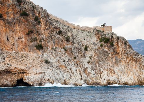 The fortified walls of Alanya Castle in Southern Turkey as viewed from the Mediterranean Sea.  The castle is located on a rocky peninsula and dates back to the 13th century.