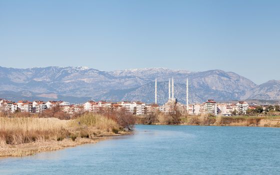 The view looking up Manavgat River towards the town of Manavgat in the province of Antalya, southern Turkey. Kulliye mosque, with its four minarets can be seen dominating the skyline.