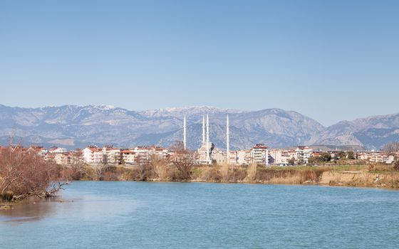 The view looking up Manavgat River towards the town of Manavgat in the province of Antalya, southern Turkey. Kulliye mosque, with its four minarets can be seen dominating the skyline.