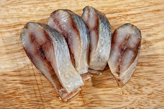 Pieces of herring ona wooden background