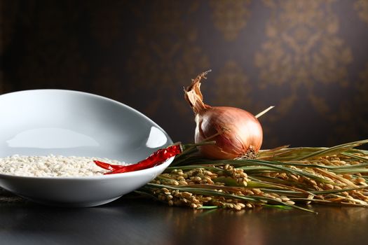 Close up of onions, rice and chilli. Healthy organic raw food ready for cooking with living room background.