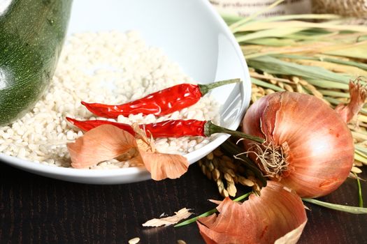 Healthy organic raw food ready for cooking. Close up of onion peel with rice corn laying on a table and rice plant