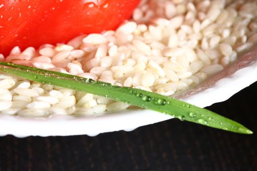 Healthy fresh organic food with water drops with rice and red pepperoni and a green leaf and rice corn