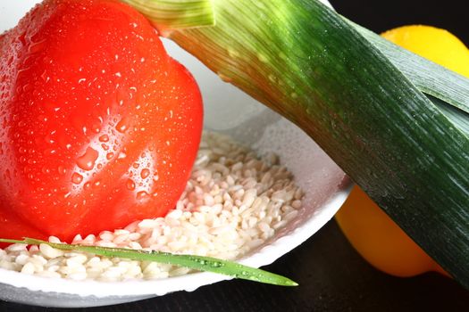 Healthy fresh organic food with water drops with rice and red pepperoni and green leek