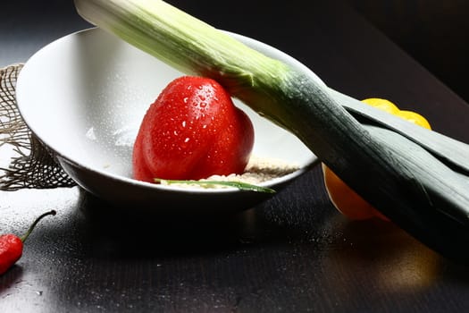 Healthy fresh organic food with water drops with rice and red and yellow pepperoni and green leek
