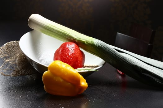 Close up of healthy fresh organic food with water drops with rice and red and yellow pepperoni and green leek