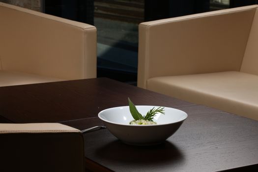 Close up of rice dish - asian food on a small dark wood table with chairs in background